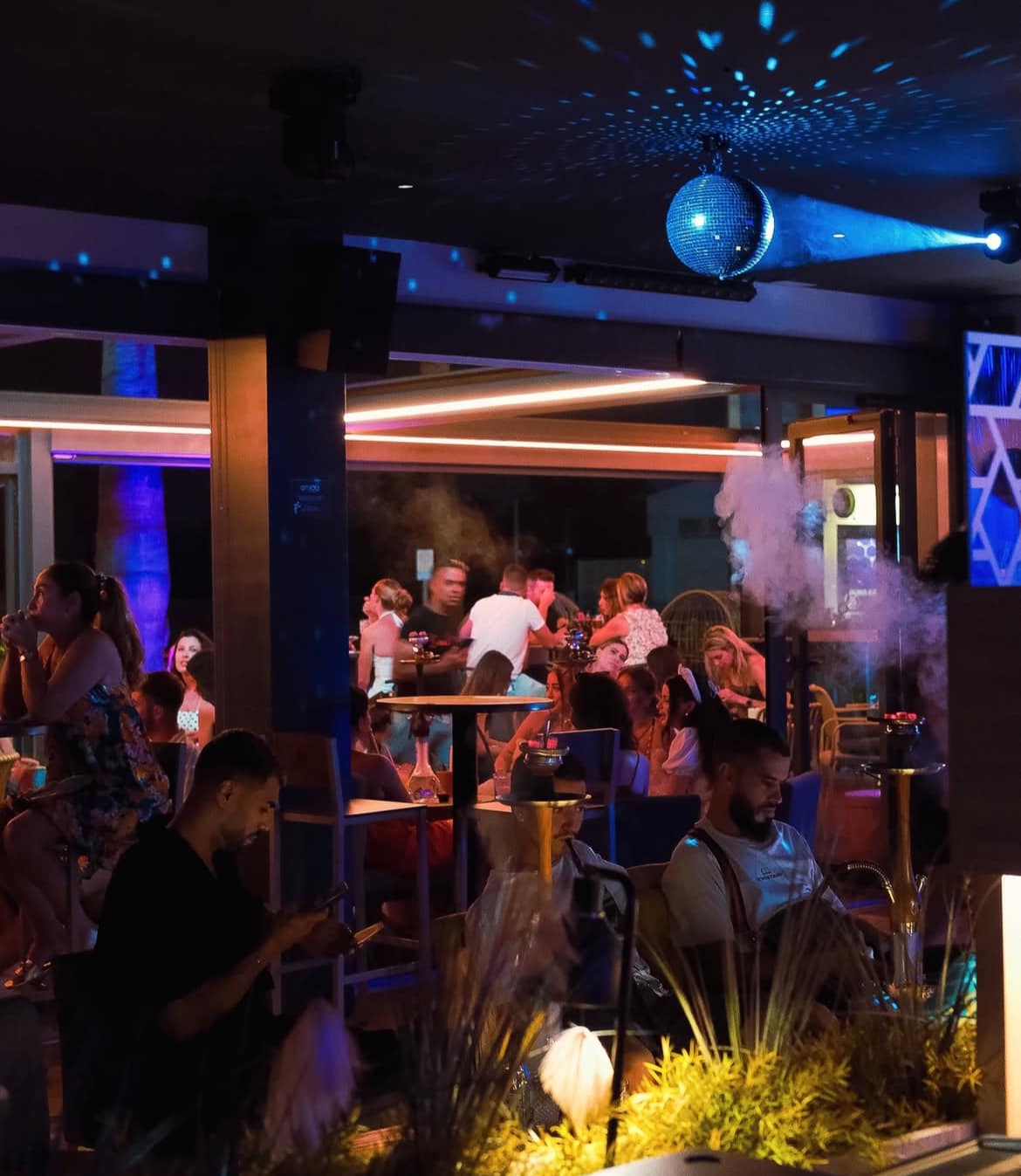 Terraza Enjoy con ambiente nocturno y shisha